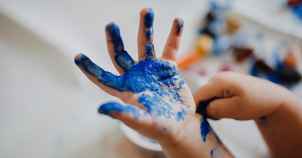 Blau angemalte Kinderhand